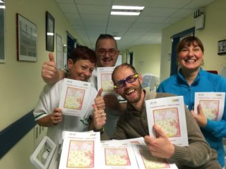 Leonardo che consegna gli opuscoli in ospedale con alcuni infermieri